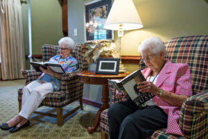 2 Woman Reading on Chairs Next to Each Other