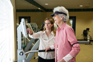 Woman Showing Another Woman Exercise Machine